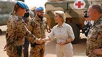 Ursula von der Leyen schüttelt die Hand einer Soldatin, dabei stehen weitere Soldaten und Personen.