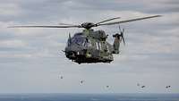 Vor grauem Himmel fliegt ein Mehrzweckhubschrauber NH-90.
